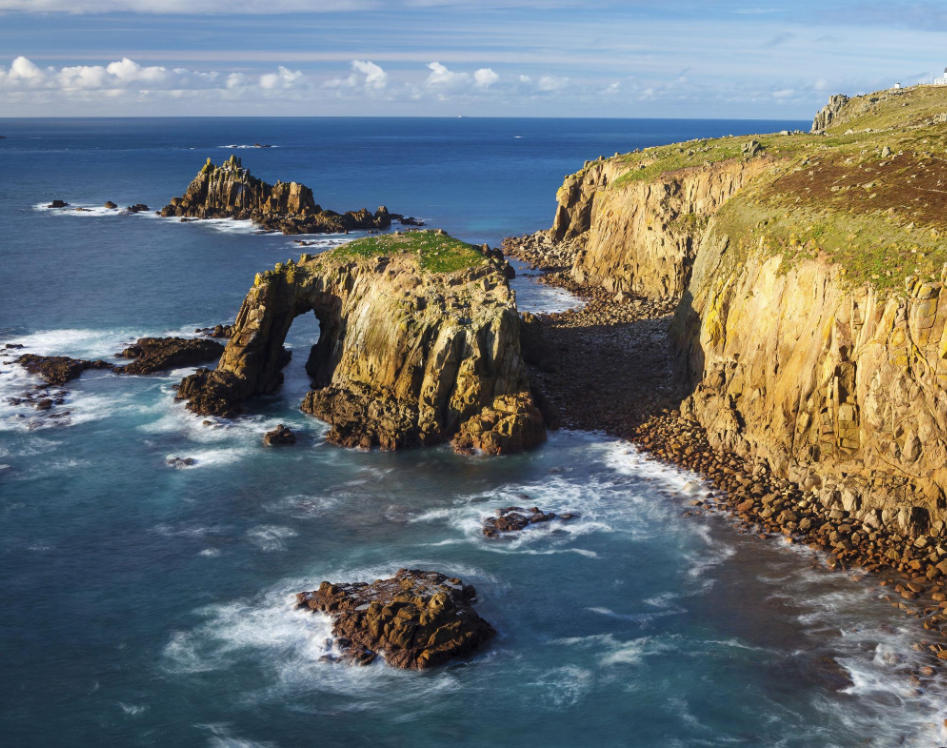 Land's End coastline and Enys Dodnan Arch in Cornwall