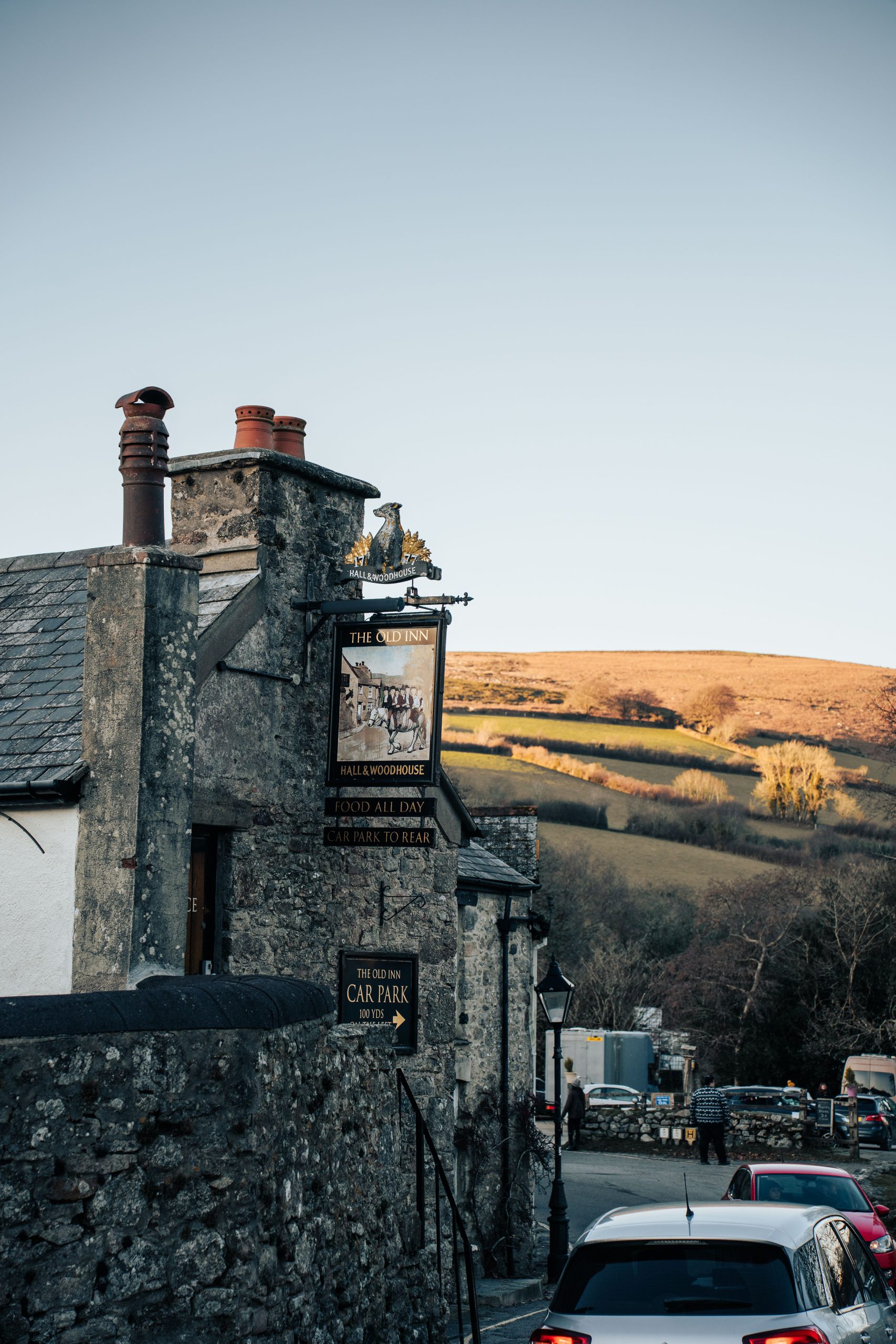 Traditional stone-built Old Inn pub near Camelford, Cornwall with rolling countryside in the background