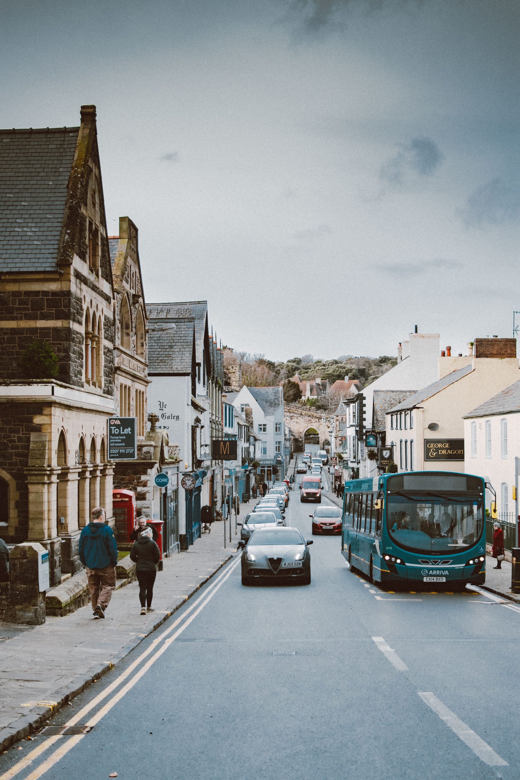 Camelford High Street with traditional shops, historic buildings and traffic in Cornwall