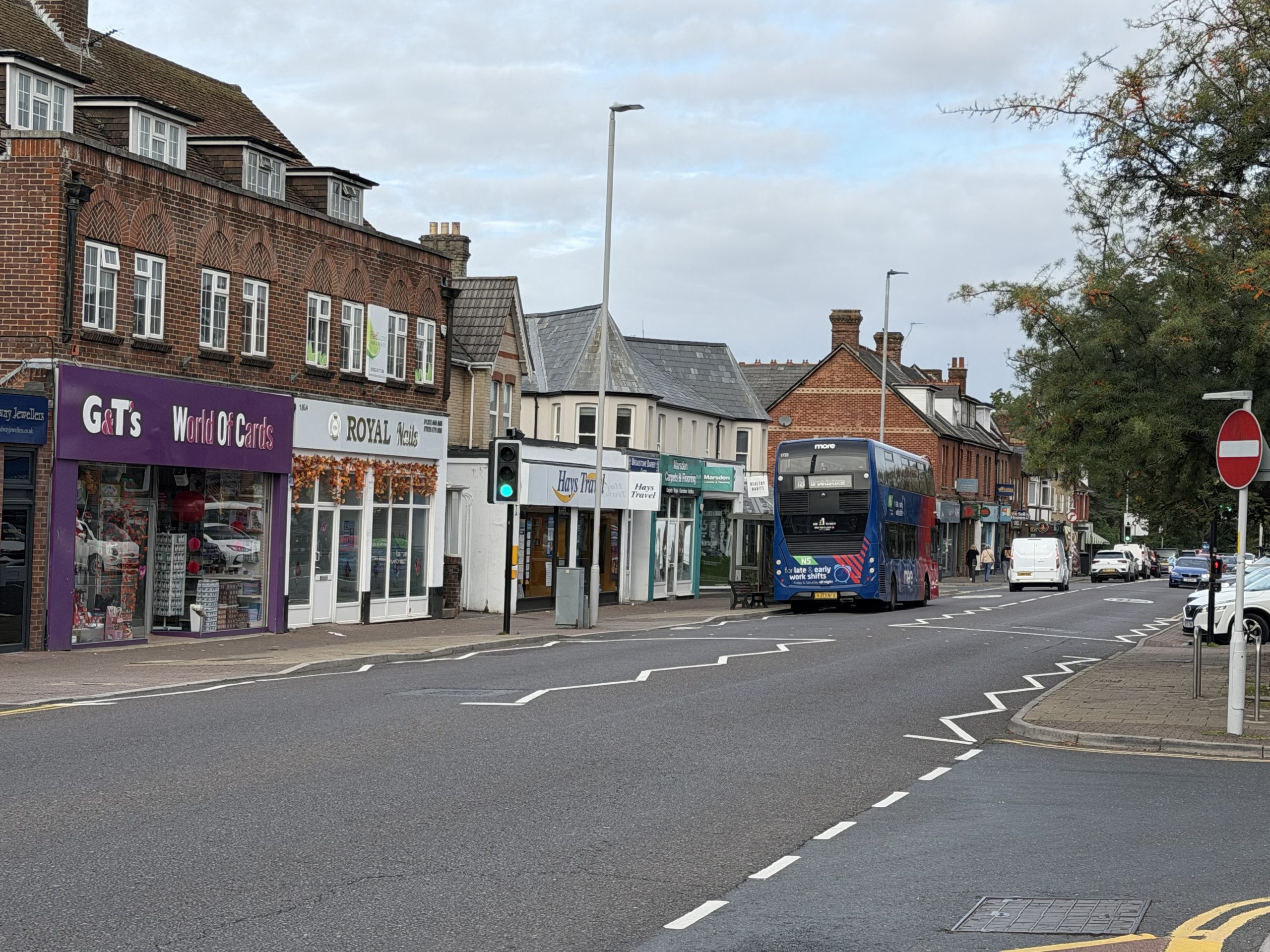 Broadstone shopping street in Poole, Dorset, with independent shops, traditional buildings and a local bus.
