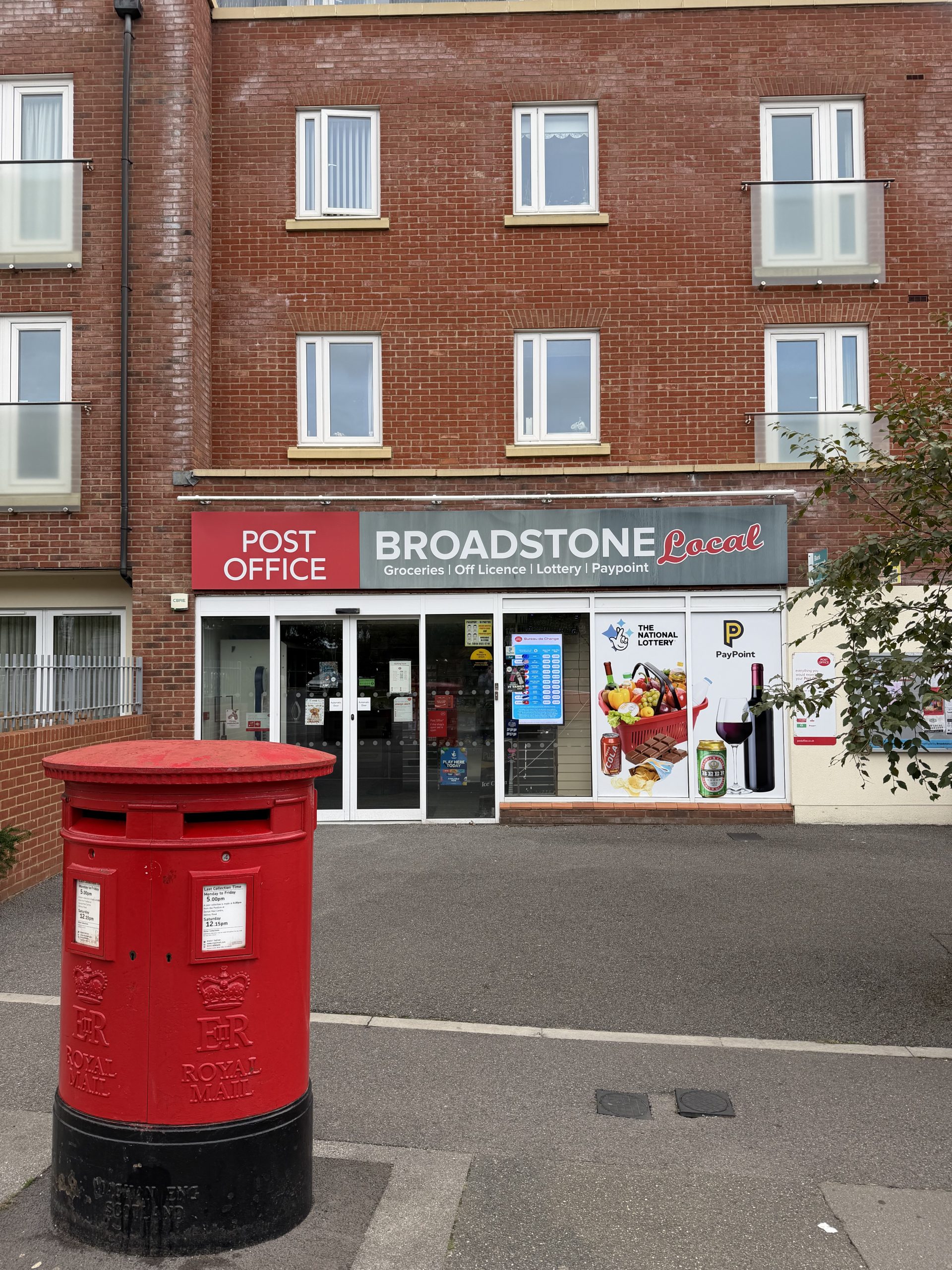 Broadstone Post Office and local convenience shop in Poole, Dorset, with a traditional red postbox outside.