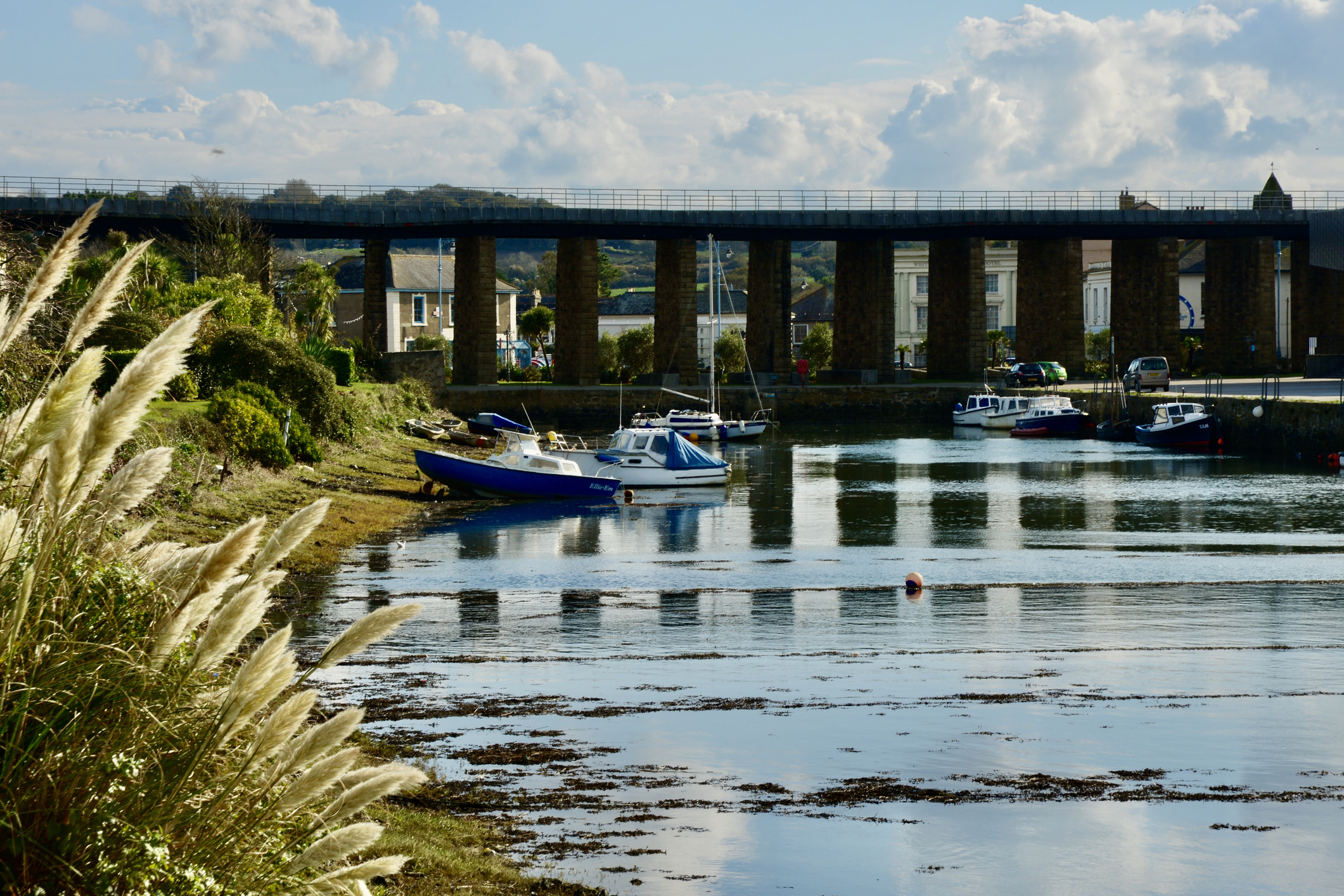Boats moored on Copperhouse Pool beneath the railway viaduct in Hayle Cornwall