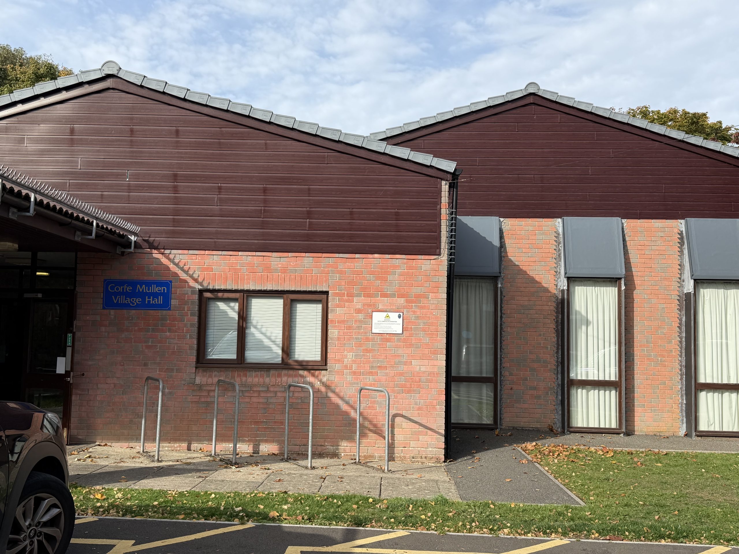 Corfe Mullen Village Hall in Dorset, showing its red-brick exterior and main entrance.