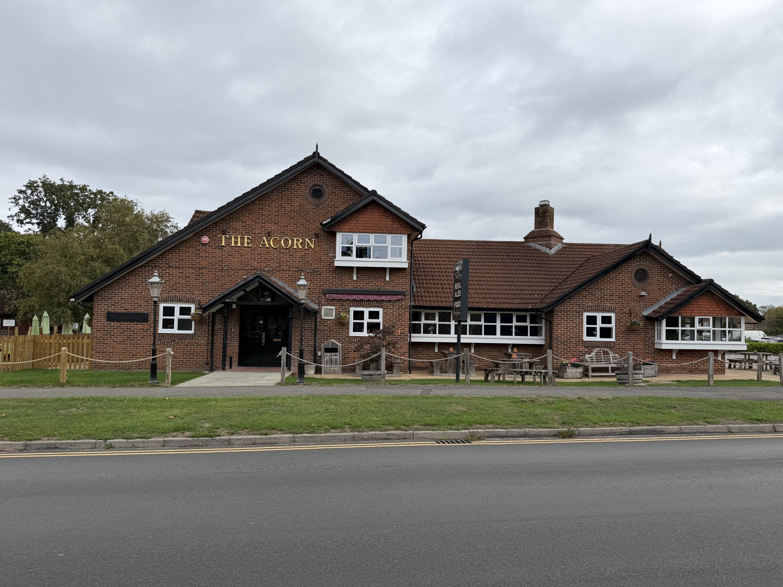 The Acorn public house in Creekmoor, Poole, Dorset, with its red-brick exterior and outdoor seating.