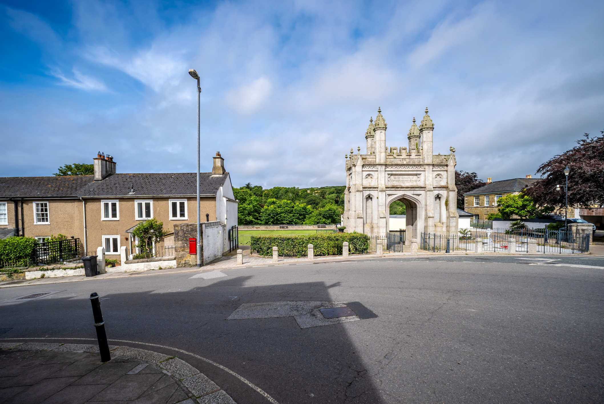 Ornate historic stone gateway with Gothic arches and traditional buildings in Cornwall