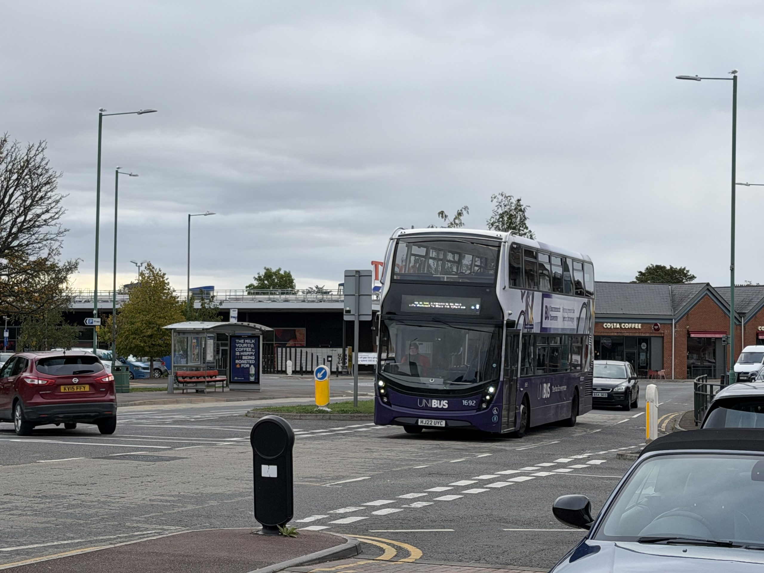 Local double-decker bus travelling through a shopping area in Kinson, Bournemouth.