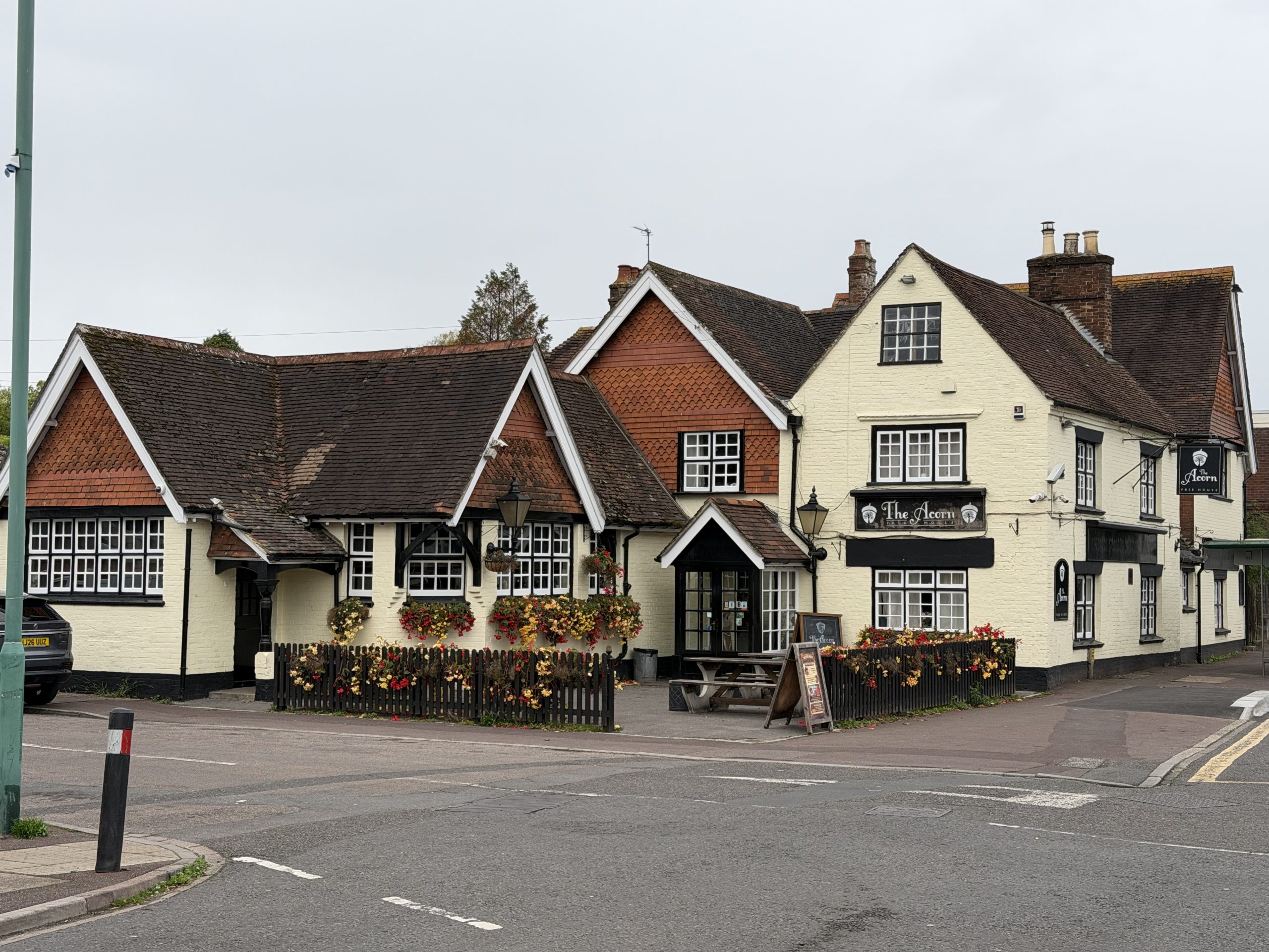 The Acorn public house in Kinson, Bournemouth, with traditional architecture and colourful flower displays.