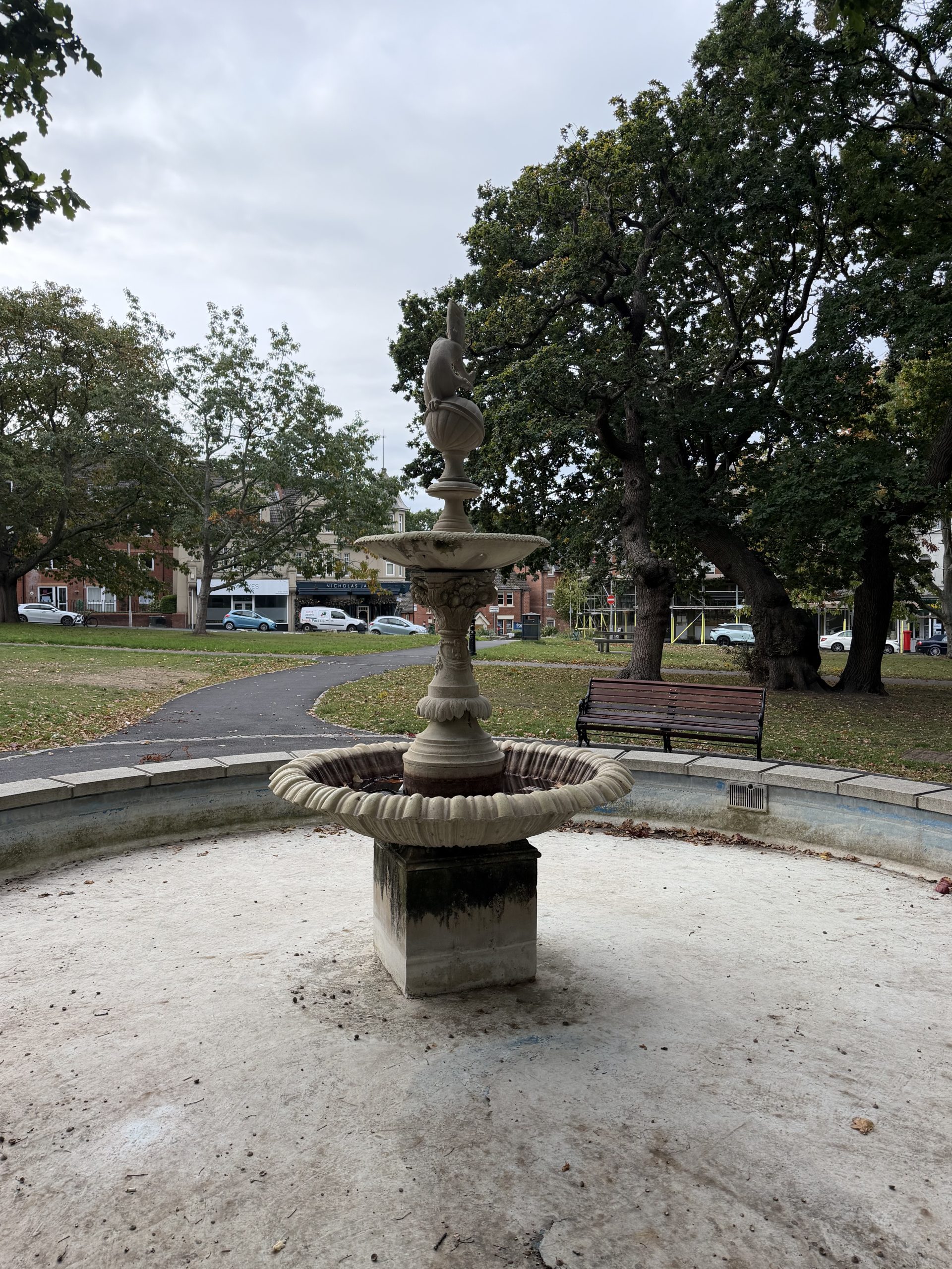 Decorative stone fountain surrounded by mature trees, seating and gardens in Parkstone, Poole.