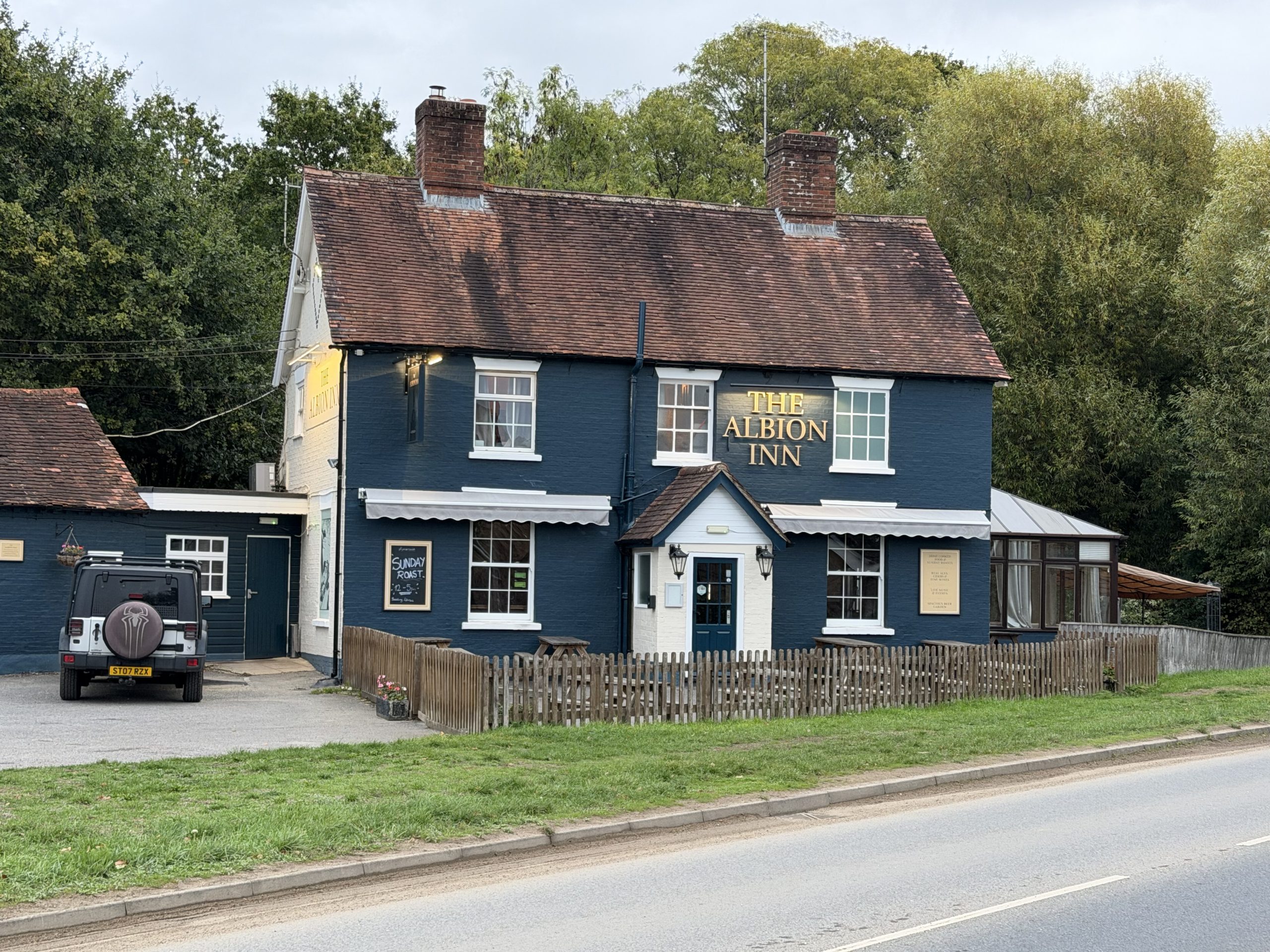 The Albion Inn in Verwood, Dorset, with its traditional blue-painted exterior and outdoor seating area.