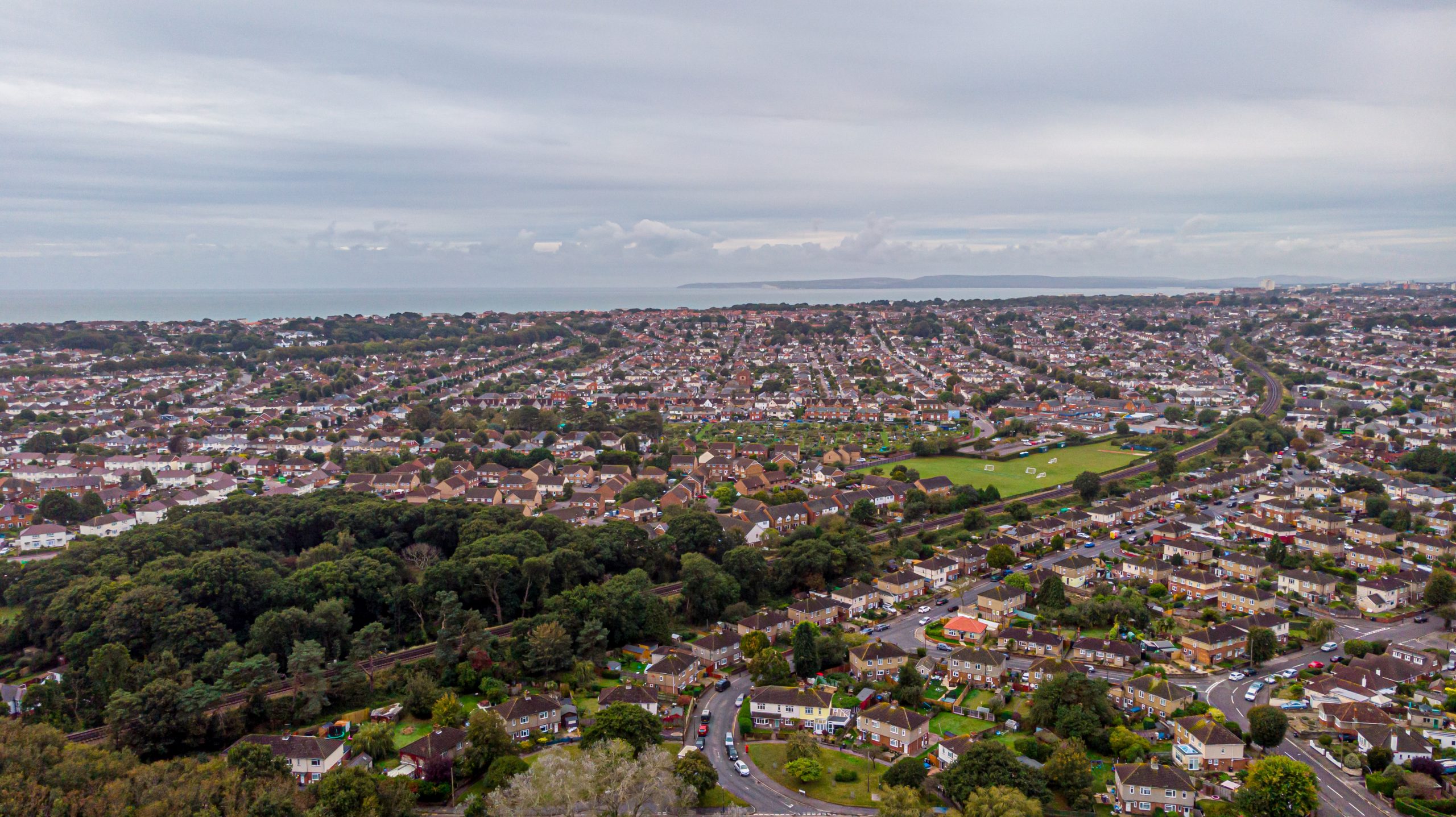 Aerial view of residential neighbourhoods near Westbourne, Dorset, with the coastline in the distance.