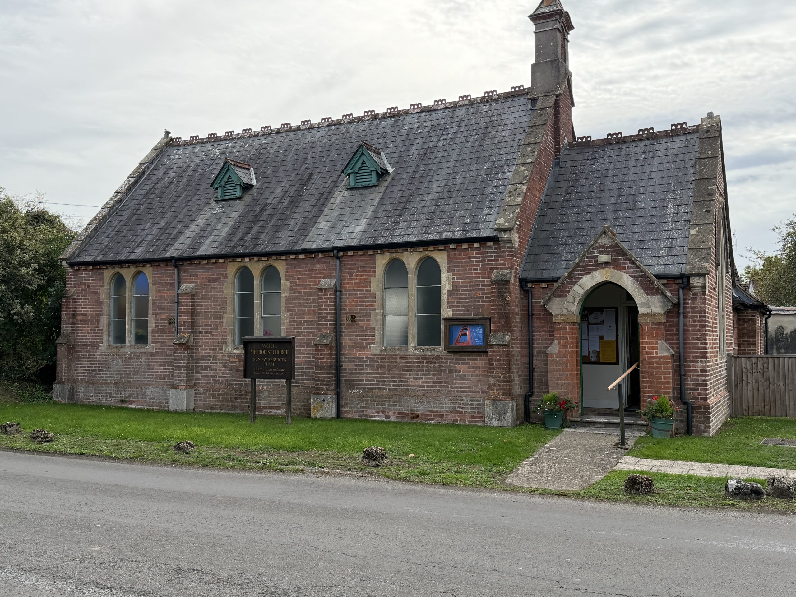Historic red-brick Wool Methodist Church with arched windows and entrance in Dorset.