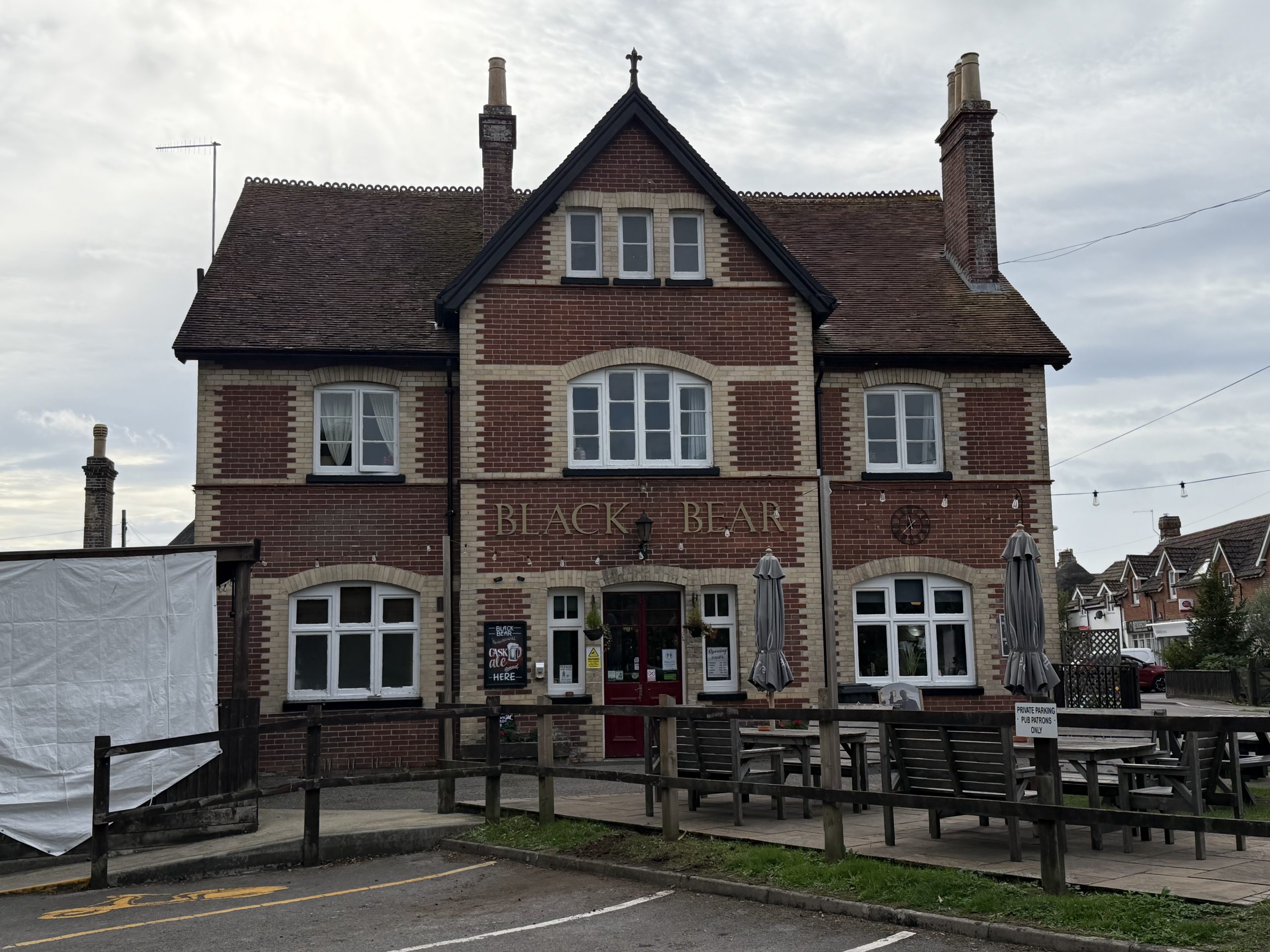 The Black Bear public house in Wool, Dorset, with its traditional red-brick frontage and outdoor seating.