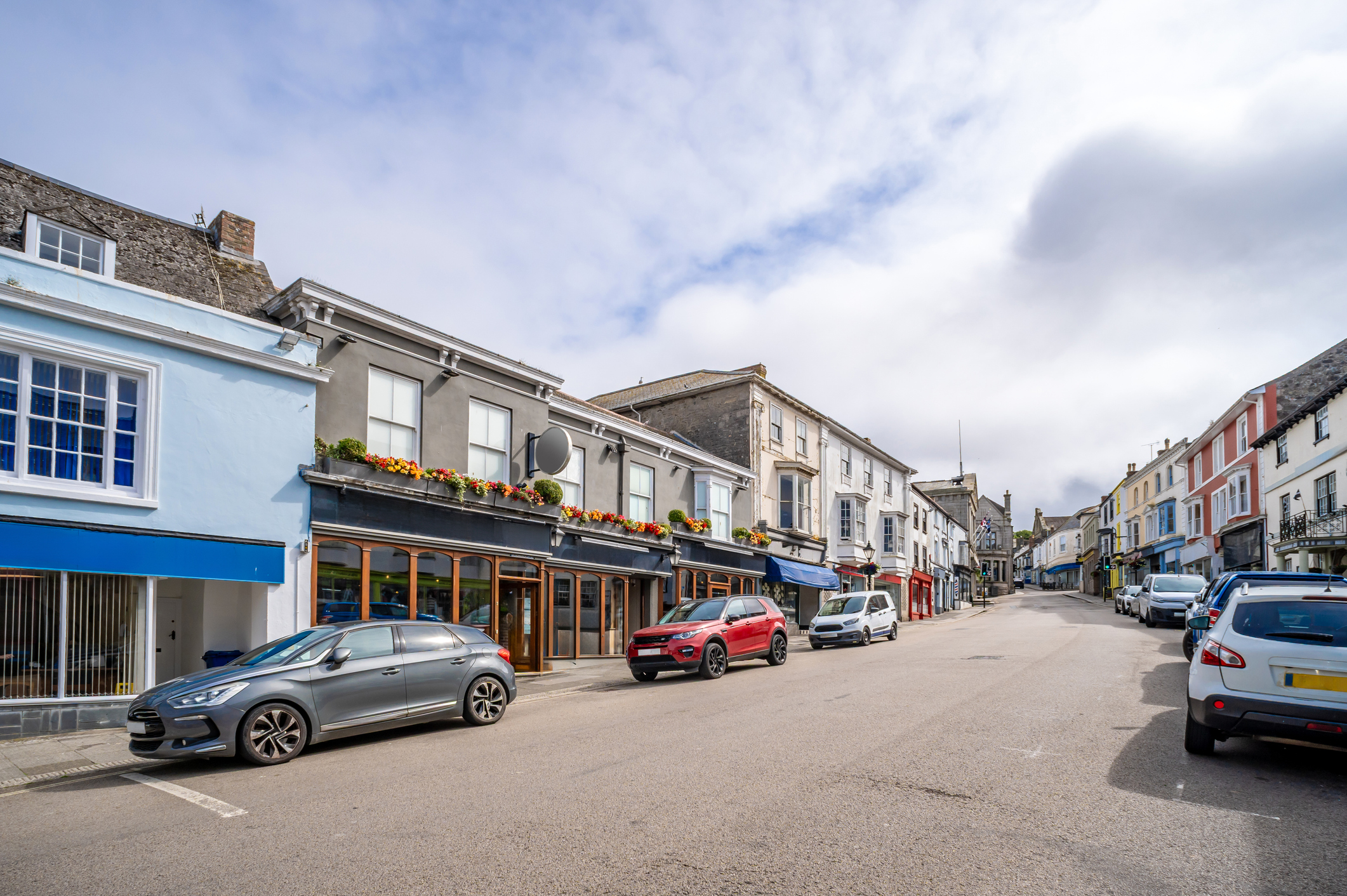 Traditional shops and historic buildings along a town centre street in Helston Cornwall